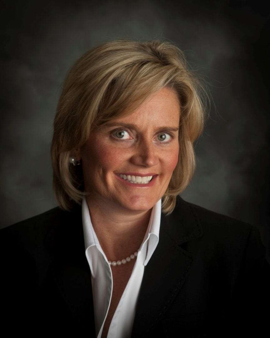 A woman in a business suit smiling for the camera at Beauchamp Consulting, where customized consultation is offered based on specific requirements.