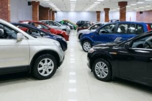 Many cars are parked in a showroom.